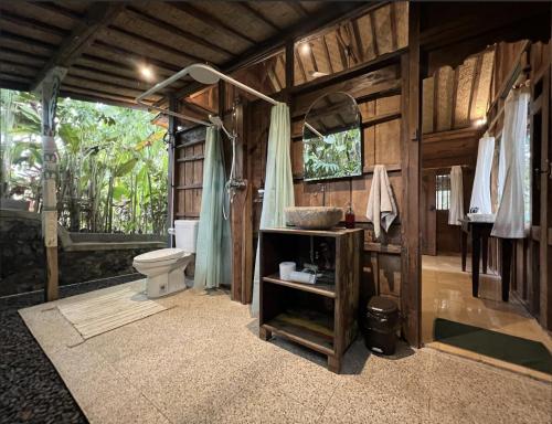 a bathroom with a toilet and a shower in it at The Manikyang Residence in Tabanan