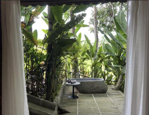 a bath tub sitting in the middle of a garden at The Manikyang Residence in Tabanan