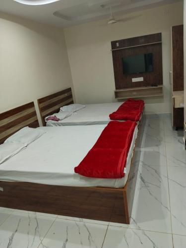 a bedroom with two beds with a red blanket at KML Grand Stay in Bhadrāchalam