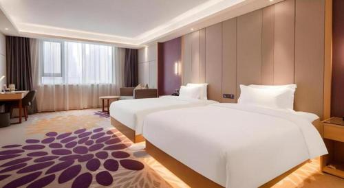 a hotel room with two beds and a desk at Lavande Hotel Changsha South High-speed Railway Station Xiyingmen in Changsha