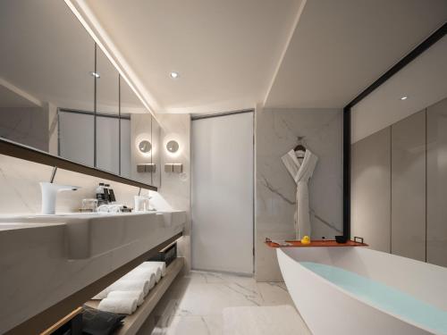 a bathroom with a sink and a white robe on a mannequin at ISEYA Serviced Apart-ment Chengdu Taikoo Li Flagship in Chengdu