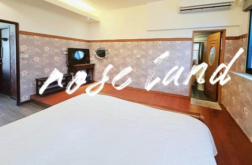 a bed in a room with a sign that readsatal at 玫瑰花園民宿親子寵物友善 in Hualien City