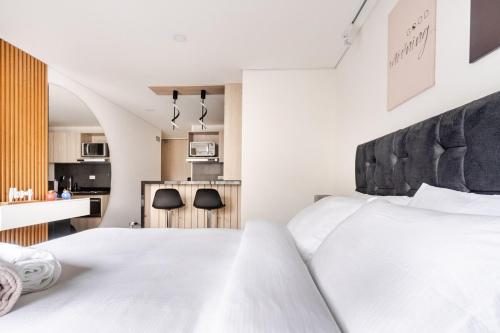 Cet appartement comprend une chambre avec un lit blanc et une cuisine. dans l'établissement Citalofty, à Bogotá