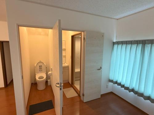 baño con aseo y cortina azul en 宿泊処 杜輝, en Oshima