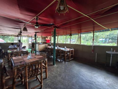 a restaurant with tables and chairs in a tent at DOHIKOTORA Eco Camp, Resort & Restaurant in Narjon Basti