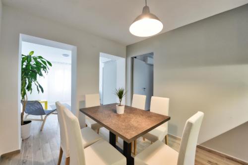 a dining room with a table and white chairs at Villa Oliver 2 Siófok in Siófok