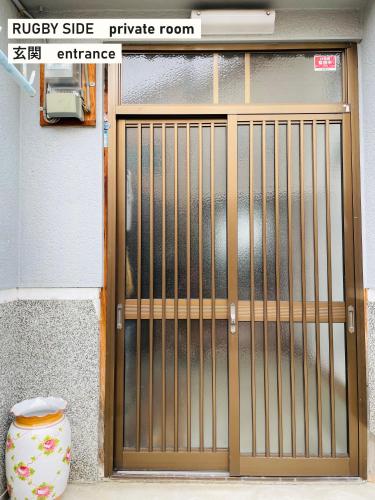 a door with a gate in front of a building at TAKIO guesthouse RUGBY SIDE in Higashi-osaka