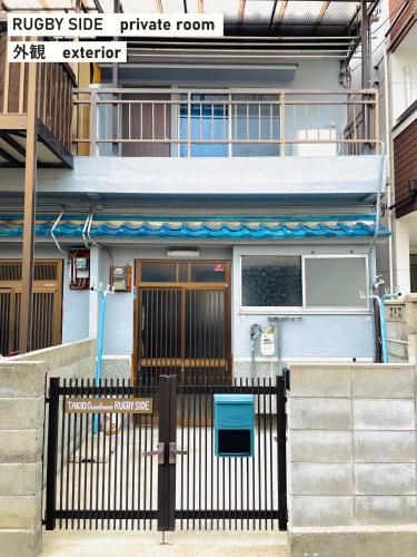 a building with a gate in front of it at TAKIO guesthouse RUGBY SIDE in Higashi-osaka