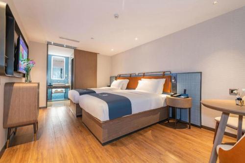 a hotel room with a bed and a table at Echarm Hotel Guangzhou Tiyu West Raod Metro Station in Guangzhou