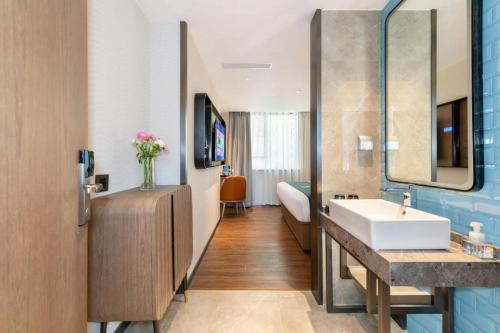 a bathroom with a sink and a mirror at Echarm Hotel Guangzhou Tiyu West Raod Metro Station in Guangzhou