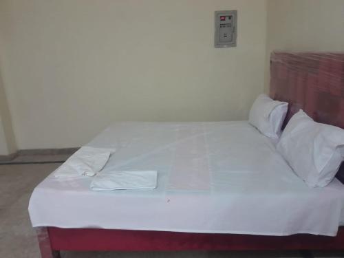 a bed with white sheets and pillows in a room at Galaxy Inn Hotel in Lahore