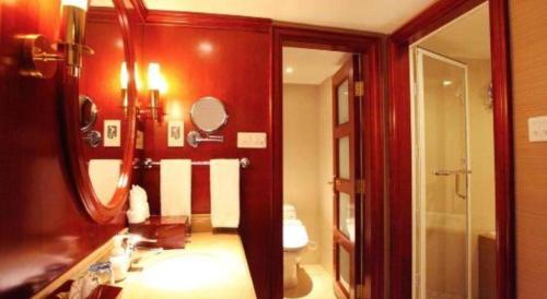 a bathroom with a sink and a mirror at Xiamen Jingmin Central Hotel in Xiamen