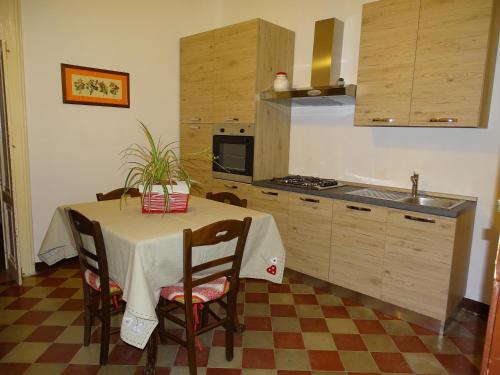 een keuken met een tafel met stoelen en een wastafel bij Palazzo Iargia in Canicattini Bagni