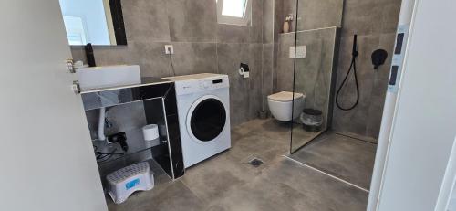a bathroom with a washing machine and a shower at Casa Elia AXD in Alexandroupoli