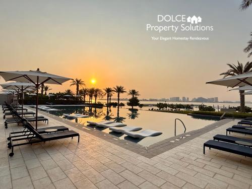 a pool with chairs and umbrellas at a resort at Address Beach Resort Residences Bahrain in Manama