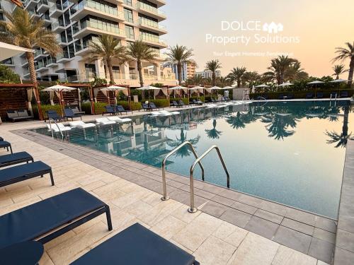 a swimming pool at a resort with chairs and umbrellas at Address Beach Resort Residences Bahrain in Manama