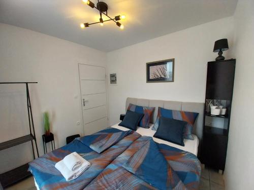 a bedroom with a large bed with blue pillows at Casa di Ljubica - Private paradise in Pula - Luxury and romance for couples, jacuzzi, massage, pool, bbq and fenced yard in Pula