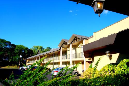 a building with cars parked in a parking lot at West Gate Inn Nyack in Nyack