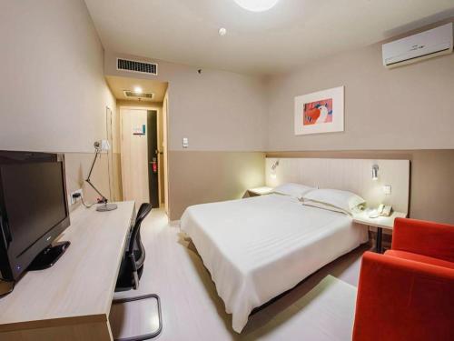 a hotel room with a bed and a television at Jinjiang Inn Baotou Donghe East Railway Station in Baotou