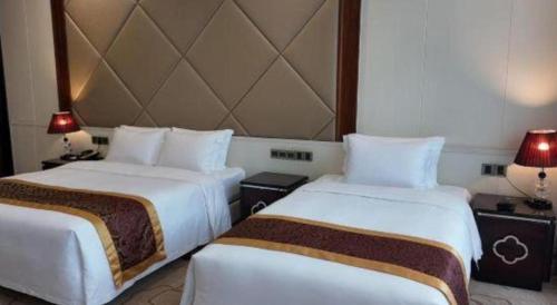 a hotel room with two beds and two lamps at SUN Yat-sen university Hotel and Conference Centre in Guangzhou