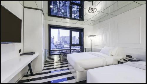 a hotel room with two beds and a flat screen tv at Hotel Forestar in Seoul