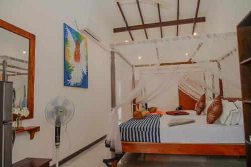 a bedroom with a canopy bed and a fan at Villa Gaetano Unawatuna in Unawatuna
