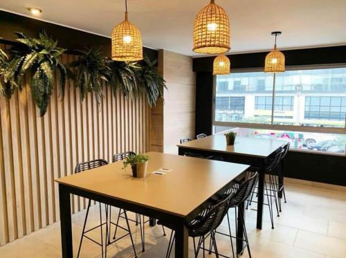 deux tables dans un restaurant avec des chaises et des suspensions dans l'établissement Departamento de Lujo en Zona Financiera y Centrica, à San Antonio