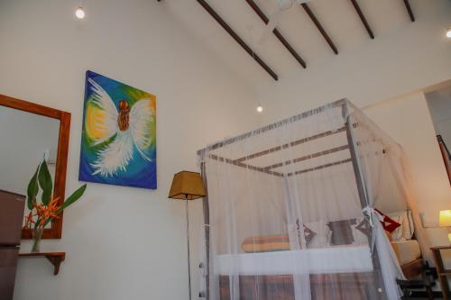 a bedroom with a bed with a canopy and a picture at Villa Gaetano Unawatuna in Unawatuna