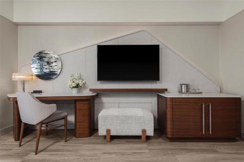 a living room with a tv and a desk and a chair at Manchester Grand Hyatt San Diego in San Diego