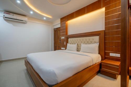 a bedroom with a large bed in a room at Hotel Staymax Trend kannur in Kannur