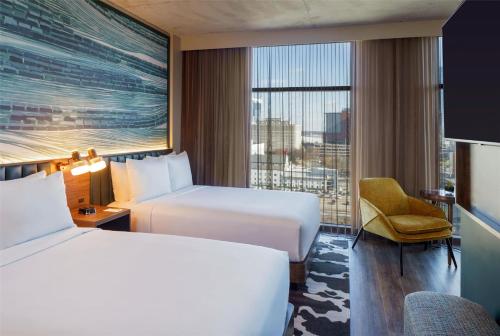 a hotel room with two beds and a window at Caption By Hyatt Downtown Nashville - The Gulch in Nashville