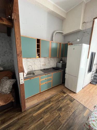 a kitchen with a refrigerator and a sink in it at Студия лофт in Chornomorsk