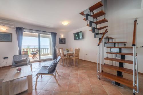 - un salon avec un escalier en colimaçon, une table et des chaises dans l'établissement Seaside Apartment Barić Draga, à Barić Draga