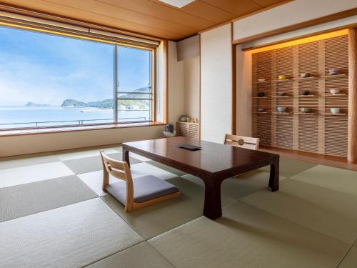 a dining room with a table and a large window at IKI RETREAT by Onko Chishin in Iki