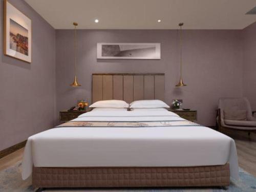 a bedroom with a large white bed in a room at Landmark Hotel in Zhuhai