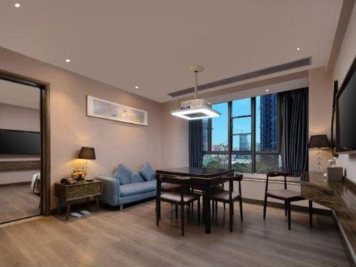 a living room with a table and a blue couch at Landmark Hotel in Zhuhai