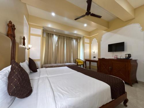 a bedroom with a large white bed and a desk at The Taj Vista Agra -walking distance to Taj Mahal in Agra