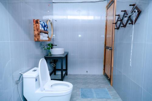 a white bathroom with a toilet and a sink at Homestay Thùy Dương 1 in Cai Be