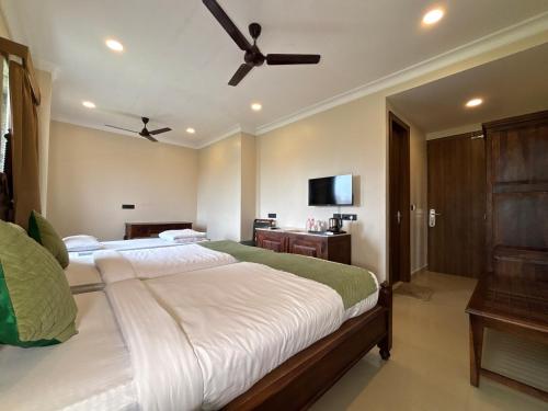 a bedroom with two beds and a flat screen tv at The Taj Vista Agra -walking distance to Taj Mahal in Agra