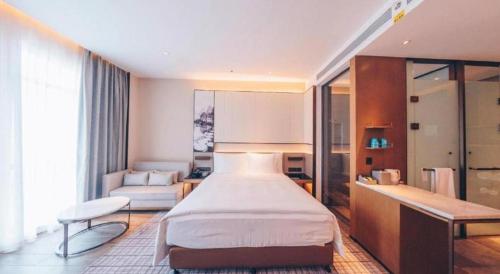 a bedroom with a bed and a living room at Wanda JIN Baise in Baise