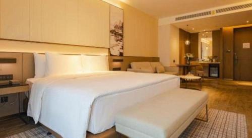 a large white bed in a hotel room at Wanda JIN Baise in Baise