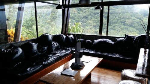 a living room with a couch and a large window at Celeste Mountain Lodge in Bijagua