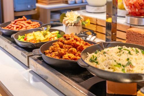 a buffet with several dishes of food on a counter at Hotel Torifito Naha Asahibashi in Naha