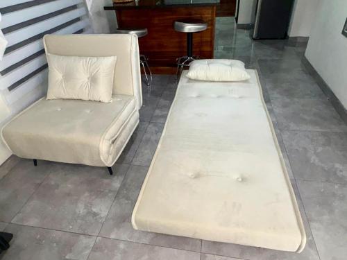 two beds and a chair in a room at Airport SJO Residence - Edward & Familia Inn in Alajuela City