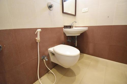 a bathroom with a toilet and a sink at Pondicherry Executive Inn in Puducherry