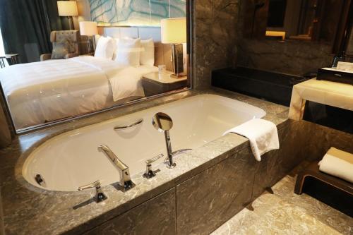 a bathroom with a bath tub with a bed at Wanda Vista Nanning in Nanning