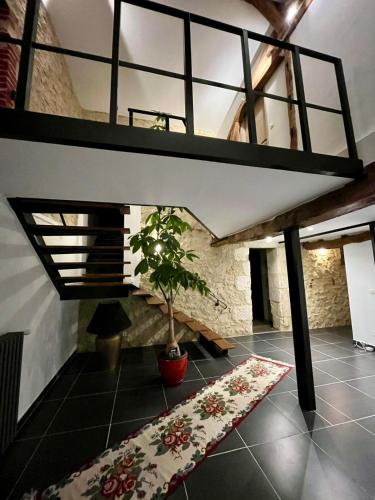 a room with a potted plant on a tile floor at Domaine de Pourrouquet - Demeure de charme et Gîte in Vic-Fezensac