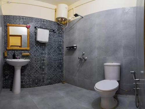 a bathroom with a toilet and a sink at Himkosi Farm by the River in Almora