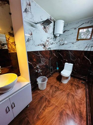 a bathroom with a sink and a toilet in it at Deep Rich Farm villa Munnar in Anachal