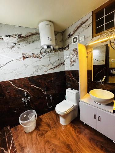 a bathroom with a white toilet and a sink at Deep Rich Farm villa Munnar in Anachal